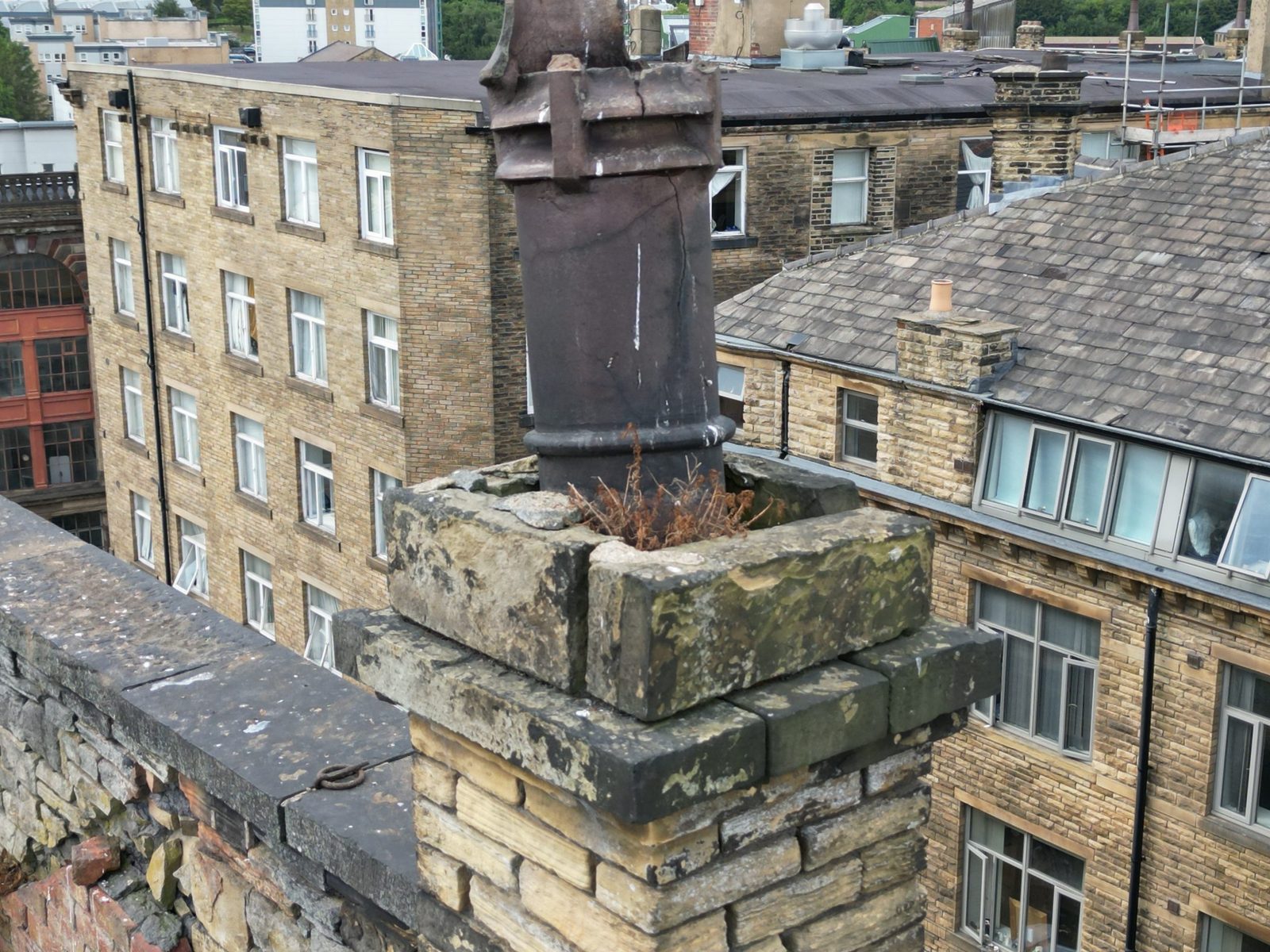 Brick chimney stack requiring repointing on a UK roof