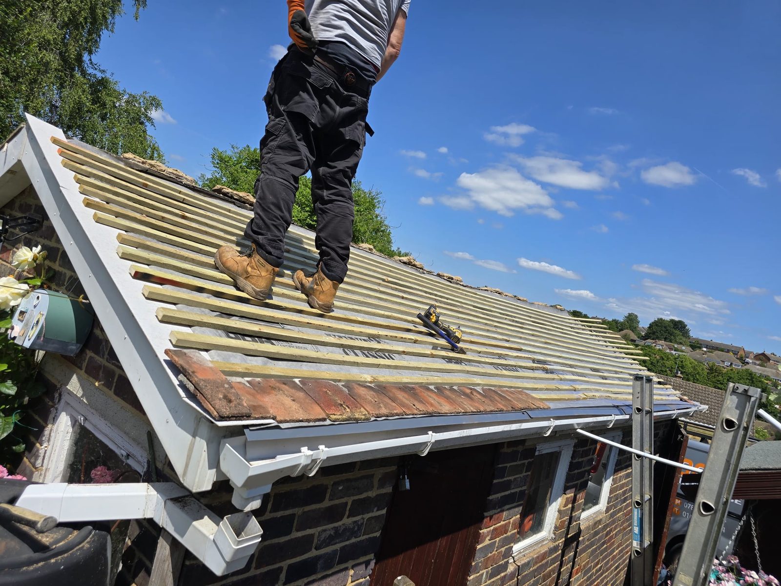 Roofer carrying out repairs on a British pitched roof